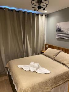 a bed with two white towels on top of it at Espaçoso II Apartamento com Piscina - Metrô Brás in Sao Paulo