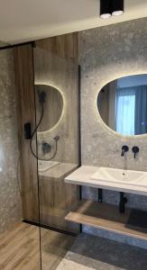 a bathroom with a sink and a mirror at Pokoje Gościnne Lidka in Dziwnów +24 photos