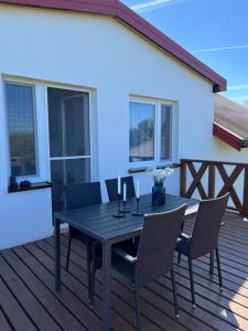 a wooden deck with a table and chairs on it at Bukszpan in Sasino +37 photos