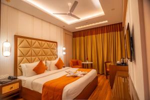 een hotelkamer met een bed met bloemen erop bij Hotel MJ Residency in Dehradun +13 foto's