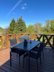 a black table and chairs on a wooden deck at Bukszpan in Sasino