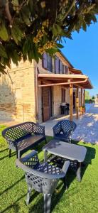 een groep banken op het gras voor een gebouw bij Il Cipresso in Casa Saraceni