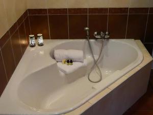 a bath tub with a shower with towels in it at Gite Coquelicot Ferme du Domaine Les Bachats Rhodes in Rhodes +16 photos