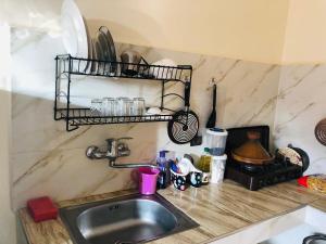 a kitchen counter with a sink and a shelf at Small house merlift in Mirleft
