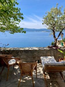 a patio with chairs and a view of the water at Blue Dream in Murvica