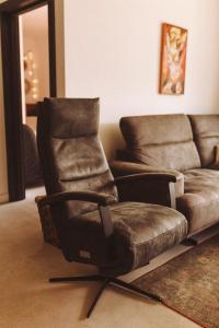 a chair and a couch in a living room at Apartament Warmiński Port 50m od jeziora in Olsztyn