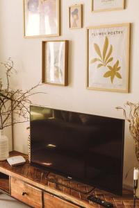 a living room with a flat screen tv on a wooden table at Apartament Warmiński Port 50m od jeziora in Olsztyn