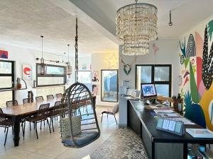 a dining room with a dining table and a chandelier at Skeleton Beach Backpackers in Swakopmund