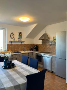 a kitchen with a table and blue chairs in it at Bukszpan in Sasino