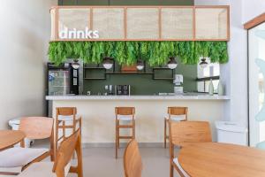 ein Esszimmer mit Holztischen und Stühlen in der Unterkunft Malia Beach Experience Muro Alto Porto de Galinhas por Brevelar in Ipojuca