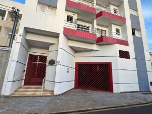 a building with two red doors and two windows at Apto Gabriel IBRANTINA PENNA in Uberaba