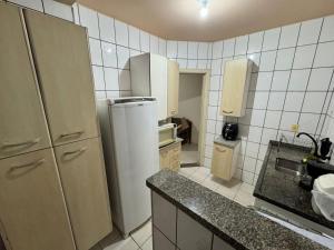 a kitchen with a refrigerator and a sink at Apto Gabriel IBRANTINA PENNA in Uberaba