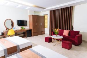 a hotel room with a bed and a couch at Hải Tiến Sunshine Hotel in Mỹ Ðuc