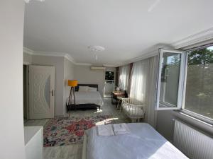 Un dormitorio con una cama y una habitación con ventana. en the nearest breakfast-inclusive hotel to the airport, en Arnavutköy