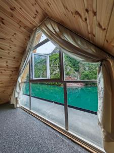 a room with a window with a view of a body of water at Riverside Komani Lake in Koman