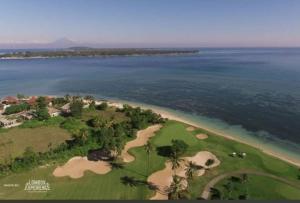 an aerial view of a golf course next to the ocean at Alma Sunset Luxury Villas Lombok in Teluk Nara