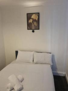 a bedroom with a white bed with a picture above it at Four Bedroom House in Gillingham in Gillingham