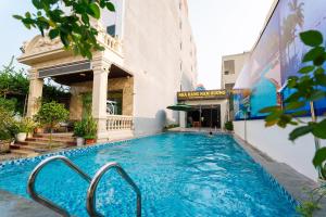 a swimming pool on the side of a building at Hải Tiến Sunshine Hotel in Mỹ Ðuc
