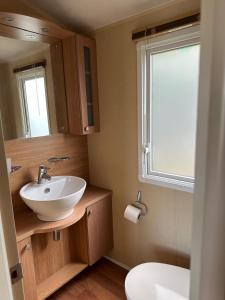 a bathroom with a sink and a toilet and a window at The Grosvner 61 in Dunoon +10 photos