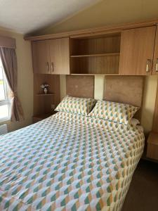 a bedroom with a large bed with wooden cabinets at The Grosvner 61 in Dunoon