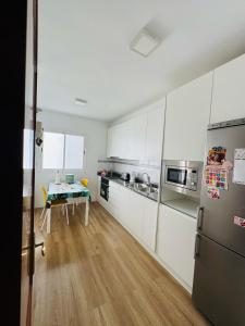 维辛达里奥Habitación Privada May con balcon的厨房配有白色橱柜和桌子
