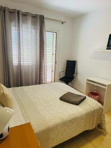 维辛达里奥Habitación Privada May con balcon的一间卧室，配有一张床、一张桌子和一把椅子