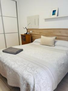 维辛达里奥Habitación Privada May con balcon的卧室配有白色的床和木制床头板