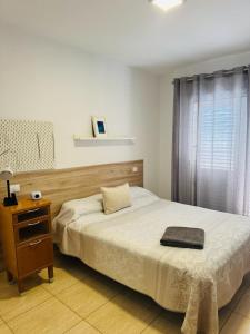 维辛达里奥Habitación Privada May con balcon的一间卧室配有一张床和一个木制床头板