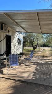 two blue chairs sitting on a patio under a building at Container Serrano in San Gerónimo +6 photos