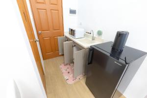 a small kitchen with a sink and a refrigerator at Tropical 2BR with Pool & Walk to Beach entry to white sand in Lapu Lapu City +11 photos