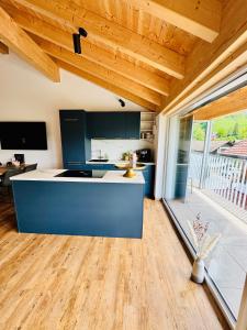 a kitchen with a blue island in the middle at Berg Fux - Ferienwohnung Louis der Fux in Sonthofen