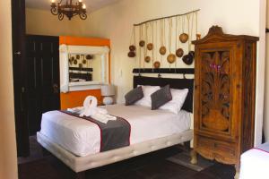 a bedroom with a large bed and a wooden cabinet at Casa Aluxes Hotel in Valladolid +95 photos