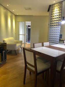 a living room with a table and chairs and a couch at São Francisco Apartment in Taboão da Serra