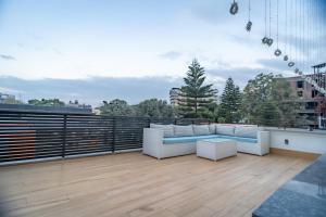 een patio met witte meubels op een dak bij Hotel MJ Residency in Dehradun
