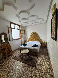 a bedroom with a bed and a table in it at Appartement Dar LALA 2 in Fez