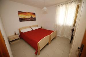 a bedroom with a large bed with a red blanket at Tropea CAPO VATICANO villa - Amphitrite in Capo Vaticano