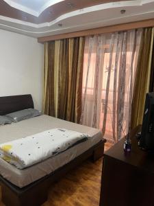 a bedroom with a bed and a window with curtains at Anastasia apartament 3 camere in Râmnicu Vâlcea