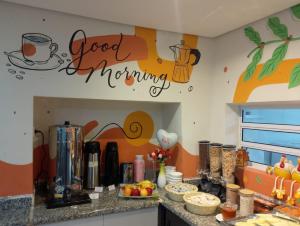 a kitchen with a good morning sign on the wall at Attriun Hotel in Guarulhos