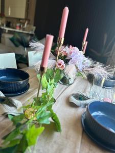 a table with blue plates and pink candles and flowers at Couple's Getaway in Is-Swieqi