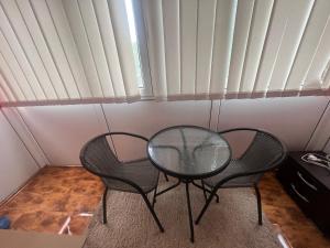 a table and two chairs in a room with a window at Anastasia apartament 3 camere in Râmnicu Vâlcea +15 photos