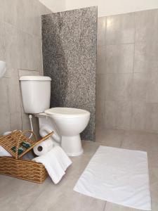 a bathroom with a toilet and a basket of towels at Residencial Girassol Outeiro in Porto Seguro