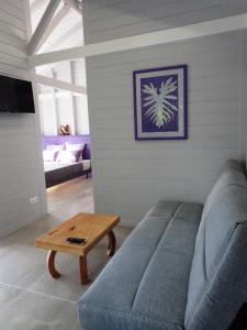 a living room with a couch and a coffee table at Caraïbes Cottages Jellyfish piscine privée a 900m de la plage de Grande Anse in Deshaies