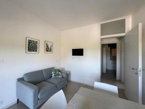 a living room with a couch and a tv at Villa Gloria appartamento D02 in Rosolina Mare
