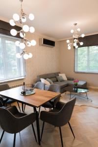 a living room with a table and a couch at Луксозен арт апартамент в близост до центъра на града in Sofia