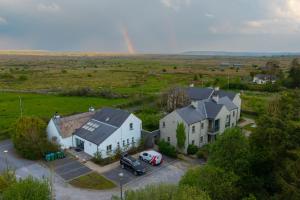 an aerial view of a house with a rainbow in the background at Burren Court Lodge in Ballyvaughan