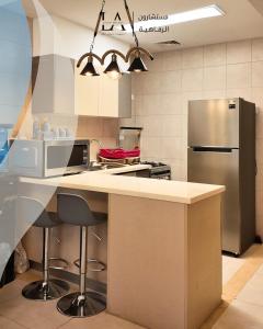 a kitchen with a counter and a refrigerator at Al RAHA village - Aqaba أستوديو بقرية الراحه العقبة مرسى زايد in Aqaba