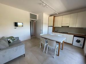 a kitchen and living room with a table and a couch at Villa Gloria appartamento D01 in Rosolina Mare
