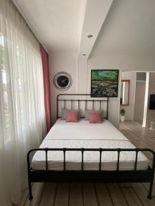 una camera con un letto con due cuscini rosa di Apartment Tijana a Bar