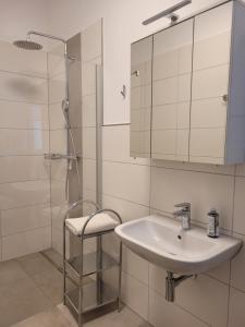 a white bathroom with a sink and a shower at Ferienwohnungen Meyer in Heilsbronn +43 photos