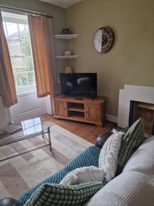 a living room with a couch and a television at Whitstone getaway in Shepton Mallet